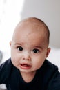 Sweet chubby cheeky baby boy lying on his tummy on the bed. Funny face expression Royalty Free Stock Photo