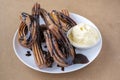 Sweet churros with chocolate and vanilla ice cream on white plate Royalty Free Stock Photo