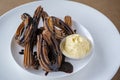 Sweet churros with chocolate and vanilla ice cream on white plate Royalty Free Stock Photo