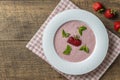 Sweet cold strawberry soup with green mint leaf in a white bowl on wooden table, closeup Royalty Free Stock Photo