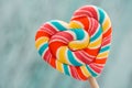 Sweet colored striped rainbow candy on a stick in the form of a heart. on a old vintage wooden background. The concept for Valenti Royalty Free Stock Photo