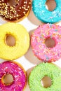Sweet colorful glazed doughnuts on white background. Junk food top view, sugar treat