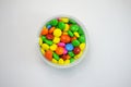 Sweet colourful candy in a jar on white background