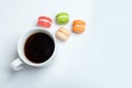 Sweet and colourful macaroons with cup of coffee on white background. Traditional french dessert. Top view, flat lay Royalty Free Stock Photo