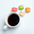 Sweet and colourful macaroons with cup of coffee on white background. Traditional french dessert. Top view, flat lay Royalty Free Stock Photo