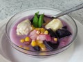 sweet compote made of starchy fruits (purple sweet potato, durian and corn) stewed in coconut milk and sugar