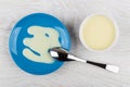 Sweet condensed milk in saucer and milk in bowl, teaspoon Royalty Free Stock Photo