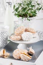 Sweet cookies on white tray with cups of coffee with green and w