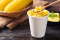 Sweet corn with butter in a biodegradable cup eating by spoon