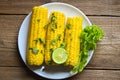 Sweet corn cooked on white plate background, sweet corn food with salad vegetable lime coriander and lettuce, ripe corn cobs Royalty Free Stock Photo