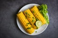 Sweet corn food with salad vegetable lime coriander and lettuce, sweet corn cooked on white plate, ripe corn cobs steamed or Royalty Free Stock Photo