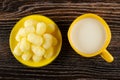 Sweet corn sticks in yellow saucer, cup with milk on wooden table. Top view Royalty Free Stock Photo