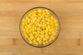 Sweet corn in transparent glass bowl on wooden table Royalty Free Stock Photo