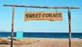 Sweet Corner sign made of wood on the beach with Aegean sea on the background, Olympiada, Greece