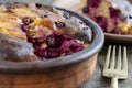 Sweet cottage cheese casserole with red cherry and semolina on wooden table. Ceramic bowl with baked cottage cheese casserole ,