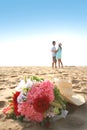 Sweet couple on the beach with bouquet