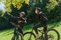 A sweet couple, equipped with bicycles and engrossed in coordinating their journey, checks their GPS mobile and watches