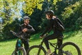 A sweet couple, equipped with bicycles and engrossed in coordinating their journey, checks their GPS mobile and watches