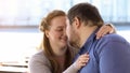 Sweet couple in love nuzzling sitting on city bench, weekend together, closeness Royalty Free Stock Photo