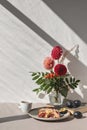 Sweet cozy autumn morning breakfast. Plum pie piece on plate, cup of tea, vase with autumn flower bouquet on table Royalty Free Stock Photo