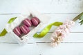 Sweet crimson french macaroons with box and hyacinth on light dyed wooden background