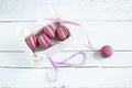 Sweet crimson french macaroons with box on light dyed wooden background