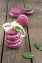 Sweet crimson french macaroons wiht hyacinth flowers and mint on dark wooden background