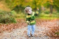 Sweet curly baby girl dancing in autumn park