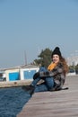 Sweet curly teen sitting on the edge of the port