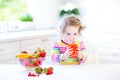 Sweet curly toddler girl having breakfast drinking juice Royalty Free Stock Photo