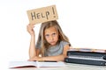 Cute blonde hair school girl holding a help sign in a education concept Royalty Free Stock Photo