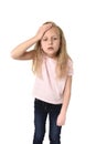 Sweet cute little female child touching her head suffering headache looking tired and sad
