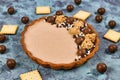 Sweet tart with cheesecake milk chocolate cream filling topped with pralines and chocolate sprinkles Royalty Free Stock Photo