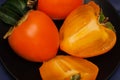 Sweet, delicious cut a ripe Persimmon in black plate, low key.