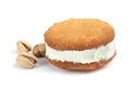 Sweet delicious ice cream cookie sandwich and pistachios on white Royalty Free Stock Photo