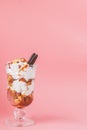 Sweet dessert in glass with biscuit and whipped cream on pink bsckground, selective focus and blank space