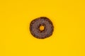 Sweet chocolate donut on yellow background. Dessert food.