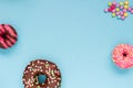 Sweet donuts with colorful candies on the blue background.