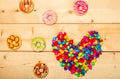 Sweet donuts with heart shaped on wooden background
