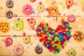 Sweet donuts pastel color with heart shaped on wooden background
