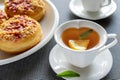 Sweet donuts on plates and cups with mint tea on the table. Royalty Free Stock Photo