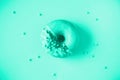 Sweet doughnut with mint icing on mint color background. Tasty donut on mint texture, copy space, top view. Trendy green and