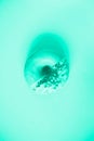 Sweet doughnut with mint icing on mint color background. Tasty donut on mint texture, copy space, top view. Trendy green and