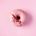 Sweet doughnut with pink icing on pastel background. Tasty donut on pink texture, copy space, top view