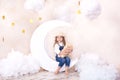 Sweet Dreams. Little cute girl sitting on the moon with clouds and stars with a teddy bear in their hands and playing. Little astr