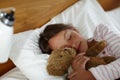 Sweet dreams with teddy by her side. a cute little girl holding her teddybear while sleeping in bed.