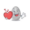 A sweet egg kitchen timer cartoon character style holding a big heart Royalty Free Stock Photo