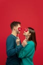 Beautiful couple in love on red studio background. Valentine's Day, love and emotions concept Royalty Free Stock Photo