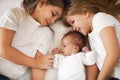 Sweet family in bed. Portrait of the three little sisters, close