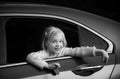 Sweet female child looking trough car window. Cute pensive girl looking through window of car.
